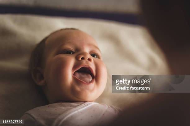 newborn baby girl laughing and giggling while playing with her mother - baby stock pictures, royalty-free photos & images