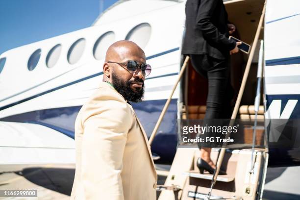 portret van een zakenman die in een corporate jet stapt - millionnaire stockfoto's en -beelden