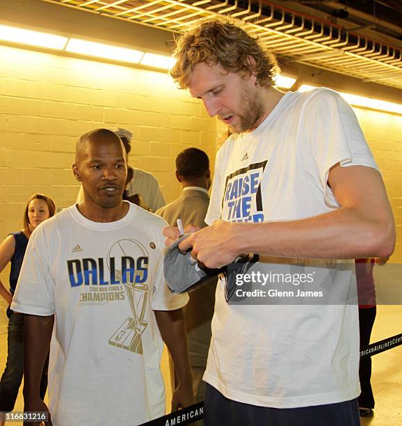 Dirk Nowitzki of the Dallas Mavericks signs an autograph for entertainer Jamie Foxx during the Mavericks NBA Champion Victory Parade on June 16, 2011...