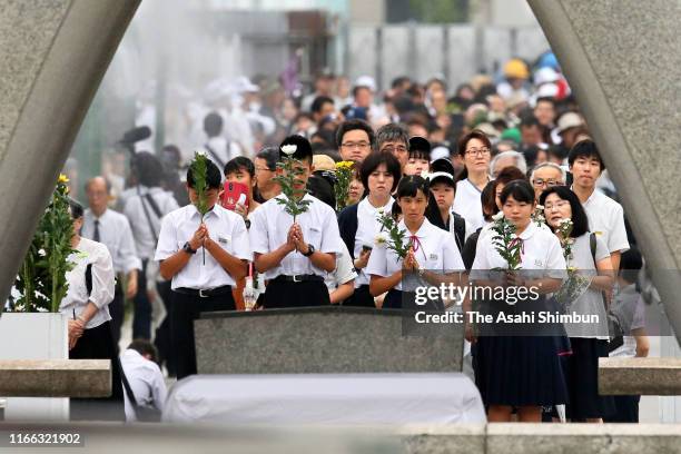 Students pray for the victims in front of the cenotaph during the Peace Memorial Ceremony on the 74th anniversary of the atomic bombing of Hiroshima...
