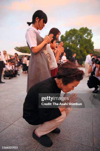 People pray for the victims in front of the cenotaph on the 74th anniversary of the atomic bombing of Hiroshima at the Hiroshima Peace Memorial Park...