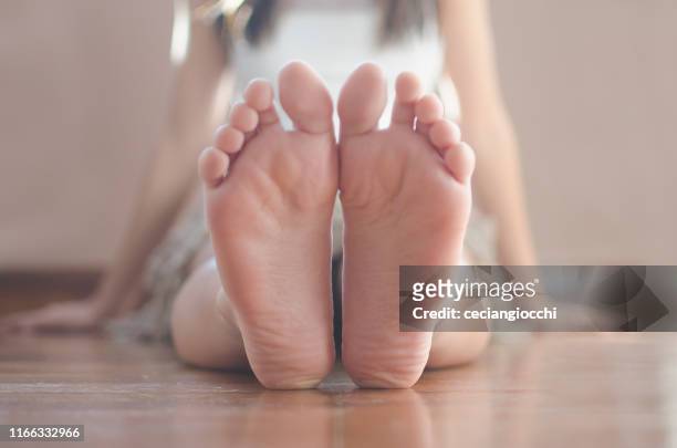 close-up of a teenage girl sitting on the floor - barefoot soles female stock pictures, royalty-free photos & images