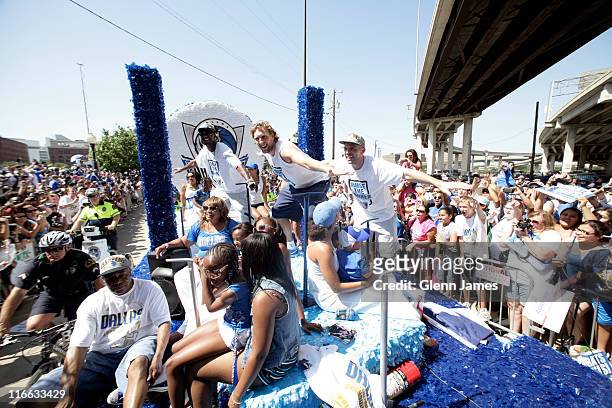 Jason Terry, Dirk Nowitzki and Jason Kidd of the Dallas Mavericks greet fans as they ride along during the Mavericks NBA Champion Victory Parade on...