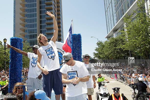 Dirk Nowitzki of the Dallas Mavericks waves to fans high and low along the route during the Mavericks NBA Champion Victory Parade on June 16, 2011 at...