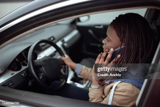 woman uses smart phone in car with daughters in backseat - distracted driving stock pictures, royalty-free photos & images