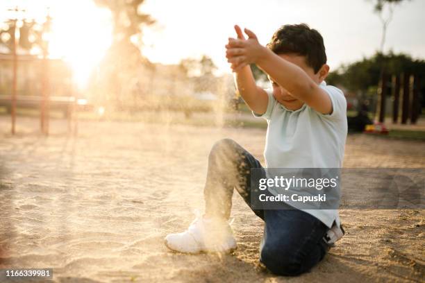 junge spielt mit sand auf spielplatz - 1 kid 1 sandbox stock-fotos und bilder