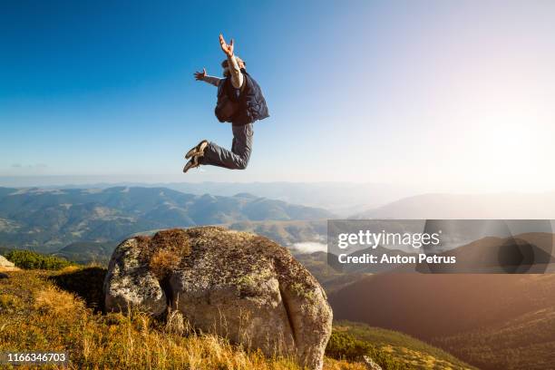 guy jumping in the mountains against the blue sky - ukraine people stock pictures, royalty-free photos & images
