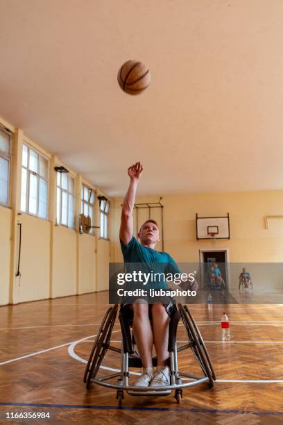 front view of handicapped basketball player throwing ball - wheelchair basketball team stock pictures, royalty-free photos & images
