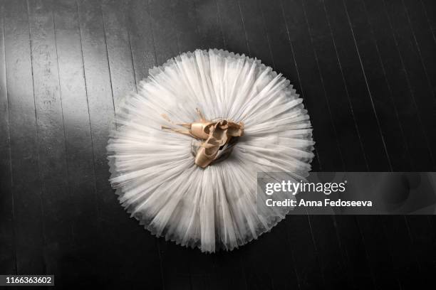 pointe shoes. peach shoes, ballet shoes with ribbons on a white tutu in a dance studio. advertising ballet school. professional ballerina outfit. - saia de bailarina imagens e fotografias de stock