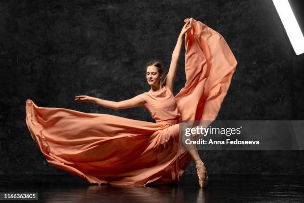 ballerina. a young ballet dancer dressed in a long peach dress, pointe shoes with ribbons. the girl performs an elegant, graceful dance movement. beautiful classic ballet. advertising ballet studio. - ballet dancers russia bildbanksfoton och bilder