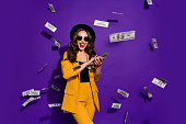 Portrait of her she nice attractive cheerful cheery positive trendy luxury wavy-haired lady throwing 100 hundred million expenses isolated over bright vivid shine violet lilac background