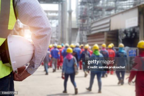 engineer or safety officer holding hard hat with construction site . - sicherheitsausrüstung stock-fotos und bilder