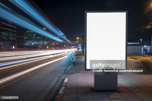 blank billboard on city street at night. outdoor advertising - placard imagens e fotografias de stock