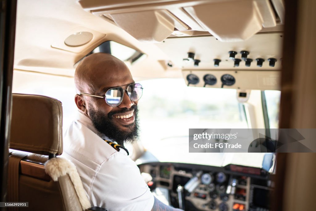 Portrait of airplane pilot looking over shoulder in a private jet