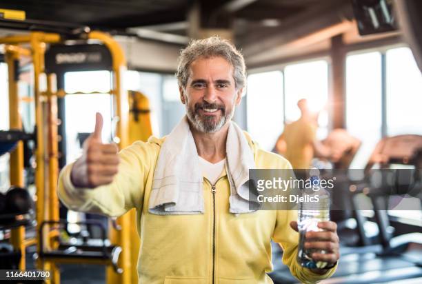 mature man in a health club showing thumb up. - sportsperson stock pictures, royalty-free photos & images