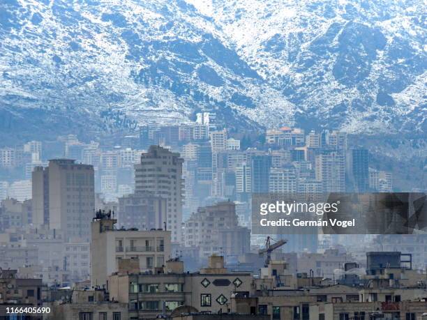 tehran urban city skyline ascending up the snowed alborz mountains - iran - tehran skyline stock pictures, royalty-free photos & images