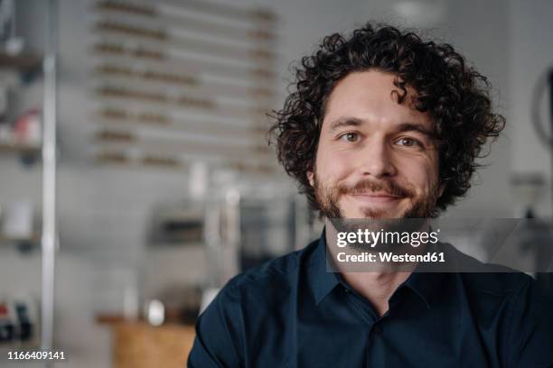 proud coffee shop owner standing behind counter - fundador fotografías e imágenes de stock