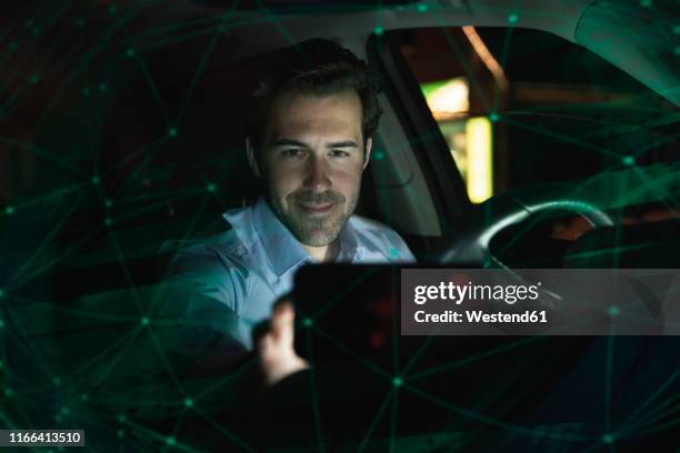 businessman using navigation device in car at night - auto daten stock-fotos und bilder