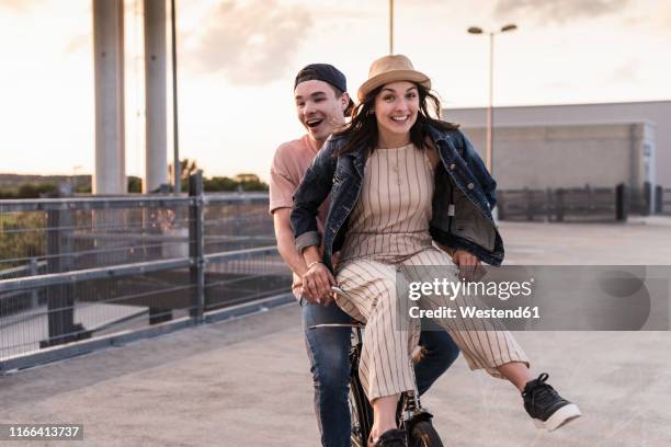 happy young couple together on a bicycle on parking deck - free and parking stockfoto's en -beelden