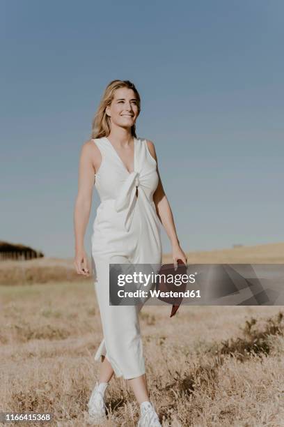 female traveller with straw hat - white jumpsuit stock-fotos und bilder