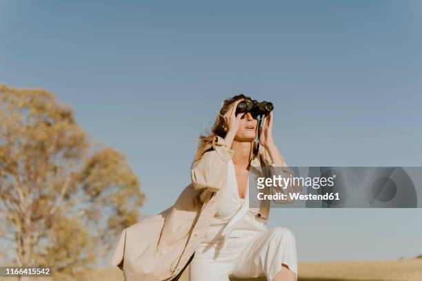 female traveller looking through binoculars - looking through binoculars stock pictures, royalty-free photos & images