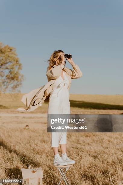 female traveller looking through binoculars - paire de jumelles photos et images de collection