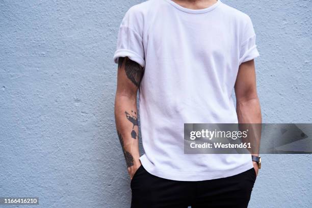 young man with tattooed arm, partial view - camiseta imagens e fotografias de stock