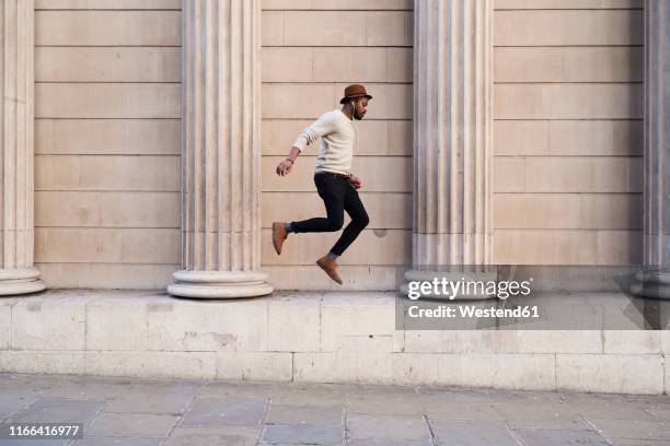 mid adult man listening music and jumping - flotando en el aire fotografías e imágenes de stock