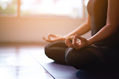 Women in meditation while practicing yoga in a training room. Happy, calm and relaxing.