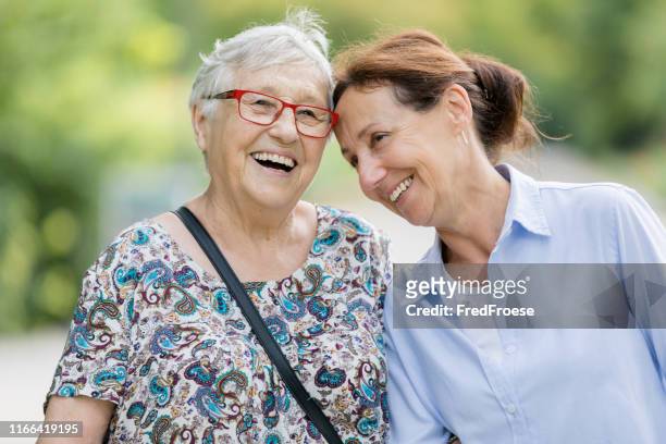 glückliche seniorin und betreuerin zu fuß im freien - nur erwachsene stock-fotos und bilder
