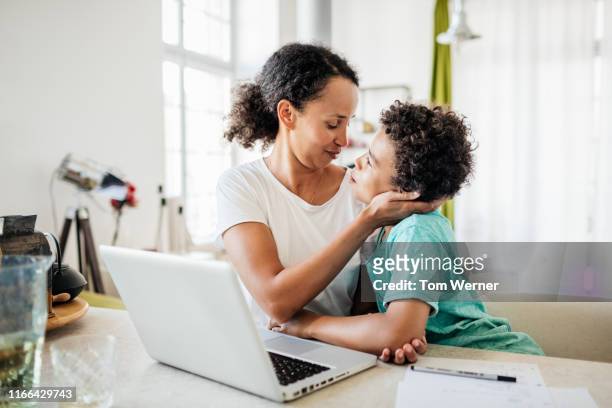 single mom being affectionate with young son - familie laptop stock-fotos und bilder