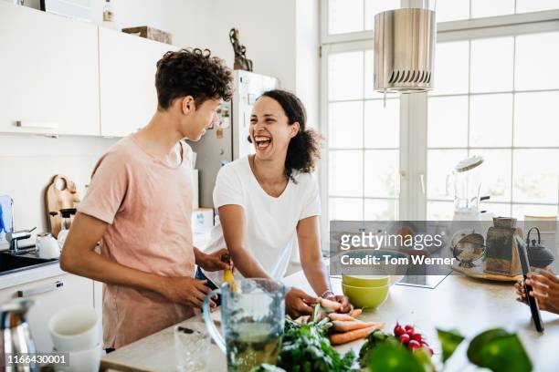 single mom laughing while preparing lunch with son - cooking stockfoto's en -beelden
