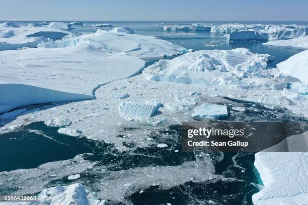 In this aerial view icebergs float at the mouth of the Ilulissat Icefjord during a week of unseasonably warm weather on August 4, 2019 near...