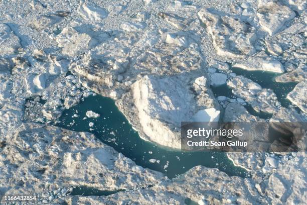 In this view from an airplane icebergs and ice float jammed in the Ilulissat Icefjord during a week of unseasonably warm weather on August 4, 2019...