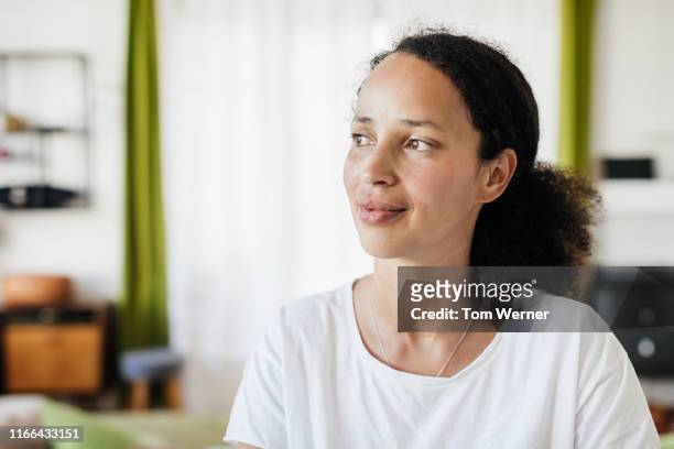 portrait of single mom relaxing at home - in den dreißigern stock-fotos und bilder