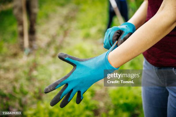 nahaufnahme von urbanen bauern setzen auf handschuh - anziehen stock-fotos und bilder