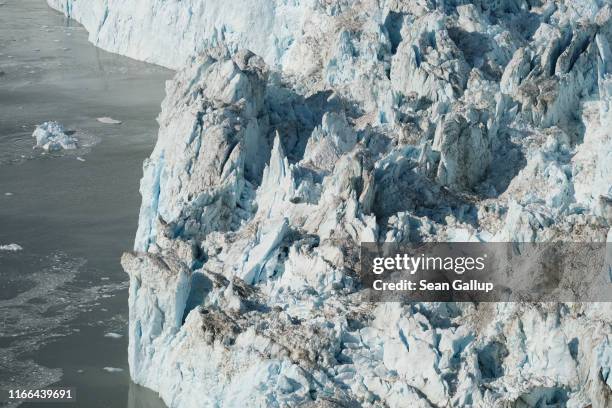 Ice that has broken off from the Eqip Sermia Glacier, also called the Eqi Glacier, drifts away from the glacier's 200 meter tall face during...