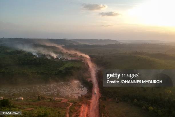 In this aerial view the red dust of the BR230 highway, known as "Transamazonica", mixes with fires at sunset in the agriculture town of Ruropolis,...