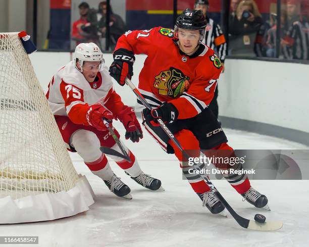 Philipp Kurashev of the Chicago Blackhawks skates around the net in front of Troy Loggins of the Detroit Red Wings of the during Day-1 of the NHL...