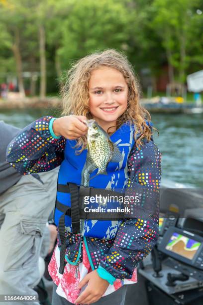 joven chica pesca en barco sosteniendo crappie fish - crappie fotografías e imágenes de stock