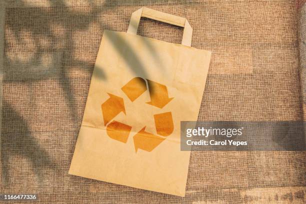 directly above recycled paper bag and green leaves - disposable imagens e fotografias de stock