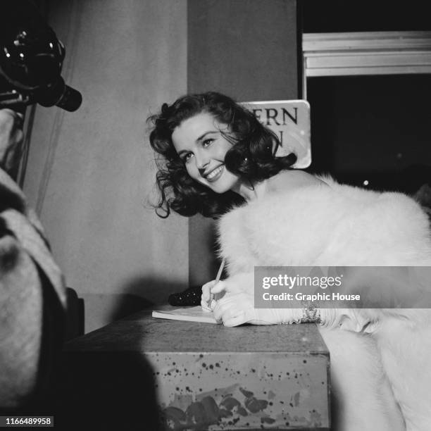 American actress Elaine Stewart signs autographs at the premiere of the film 'Knights of the Round Table' in Los Angeles, California, 22nd December...