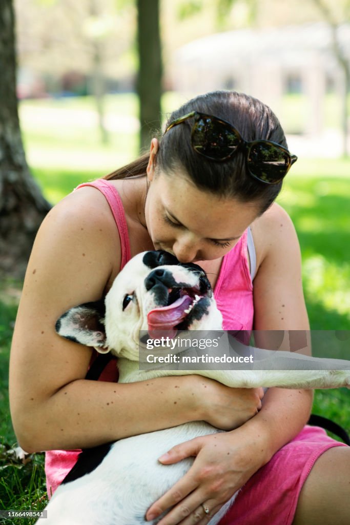 Mujer joven adulta en un parque con un bulldog francés