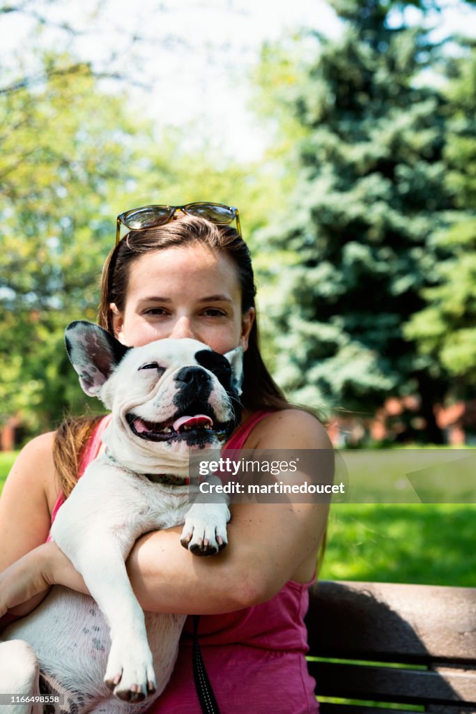 Mulher adulta nova em um parque com um buldogue francês