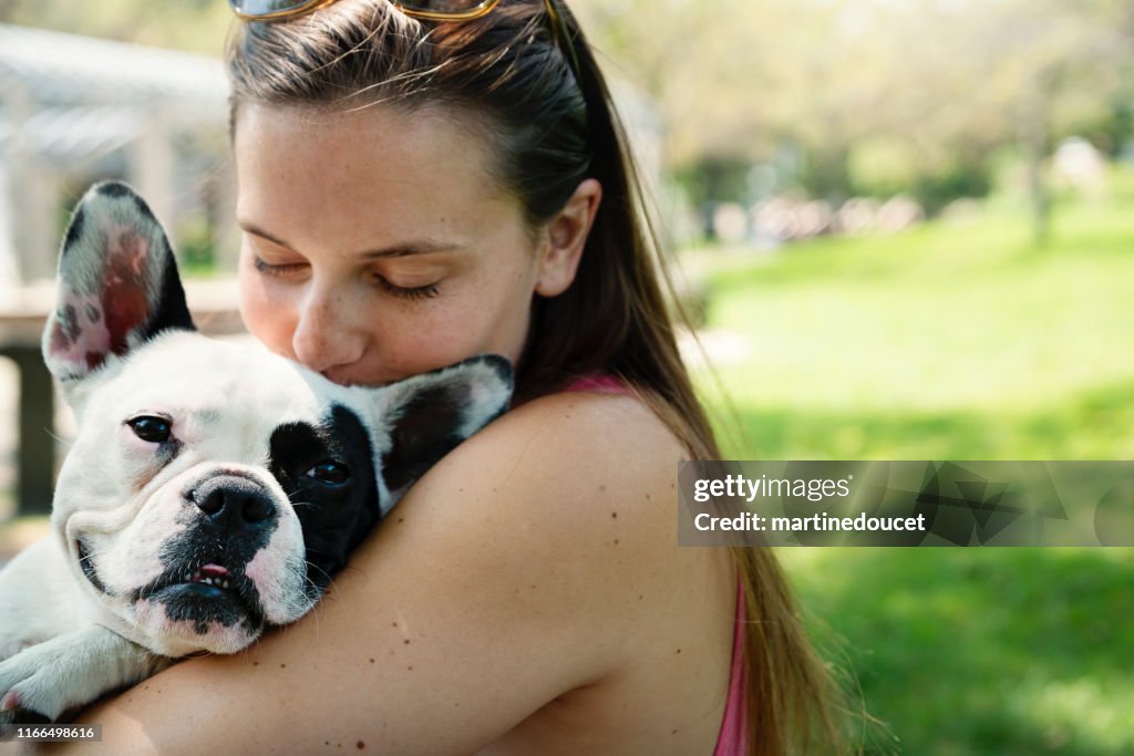 Jonge volwassen vrouw in een park met een Franse Bulldog