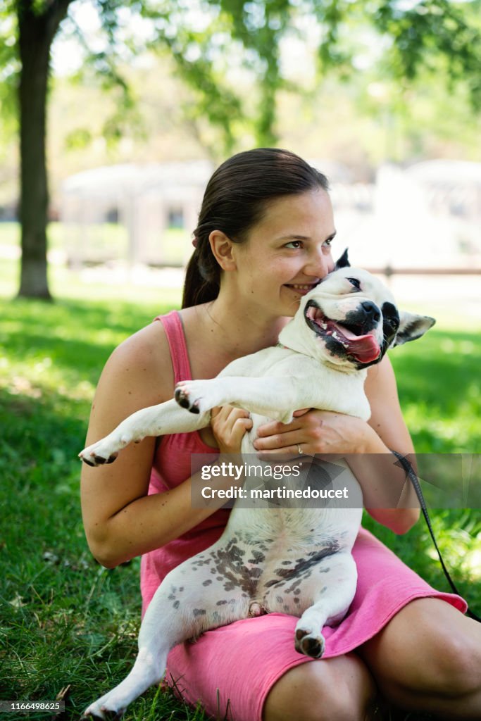 Jonge volwassen vrouw in een park met een Franse Bulldog