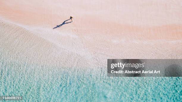 drone image of a girl running along a beach, australia - sand stock pictures, royalty-free photos & images