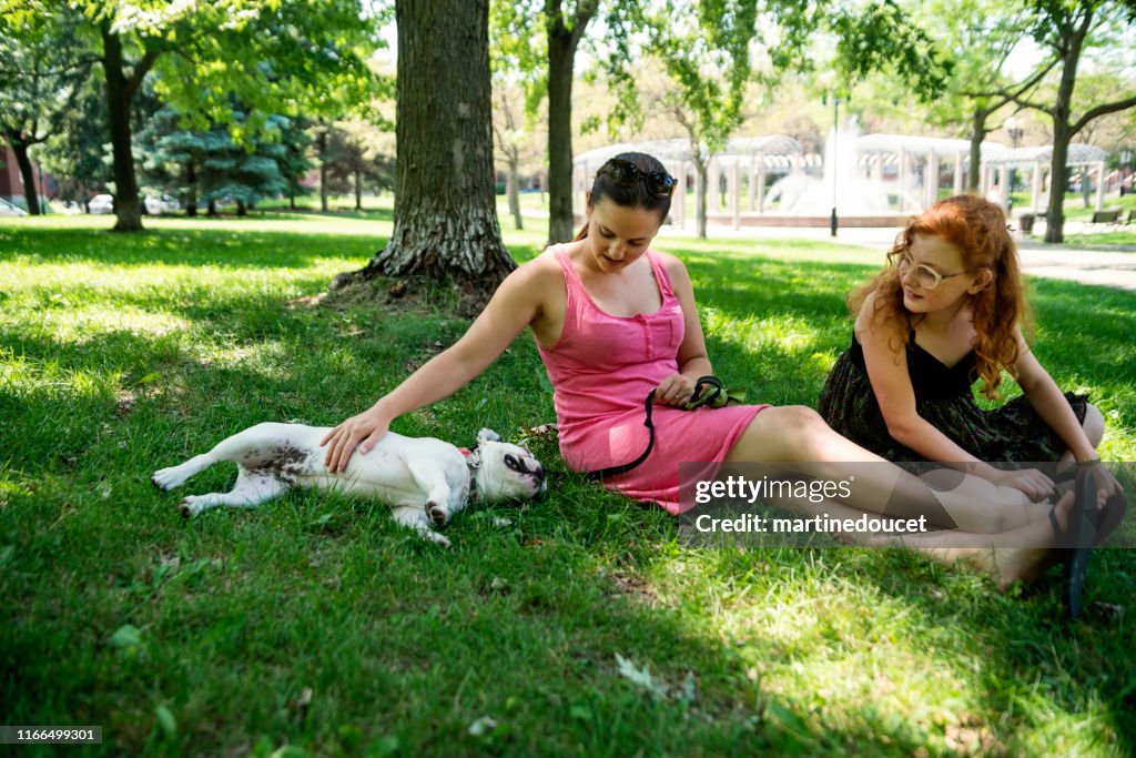 Two girls in a park with a dog