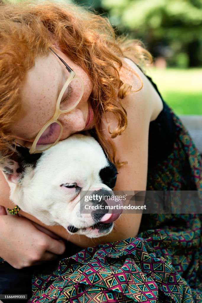 Teenage redhead girl in a park with a dog