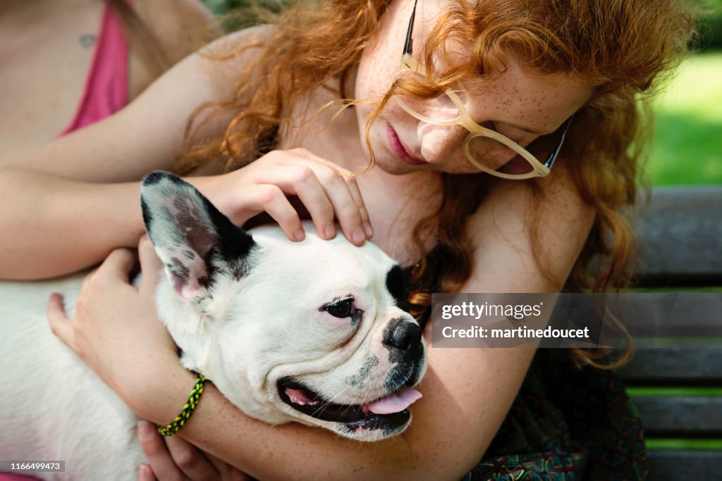Adolescente pelirroja en un parque con un perro